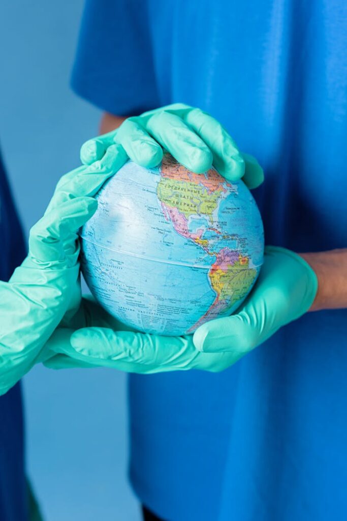 People wearing Latex Gloves holding a Globe